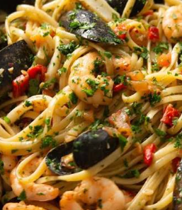 Seafood pasta with prawns, snails, shrimps, crab and calamari, plantain, boiled egg and soft drink